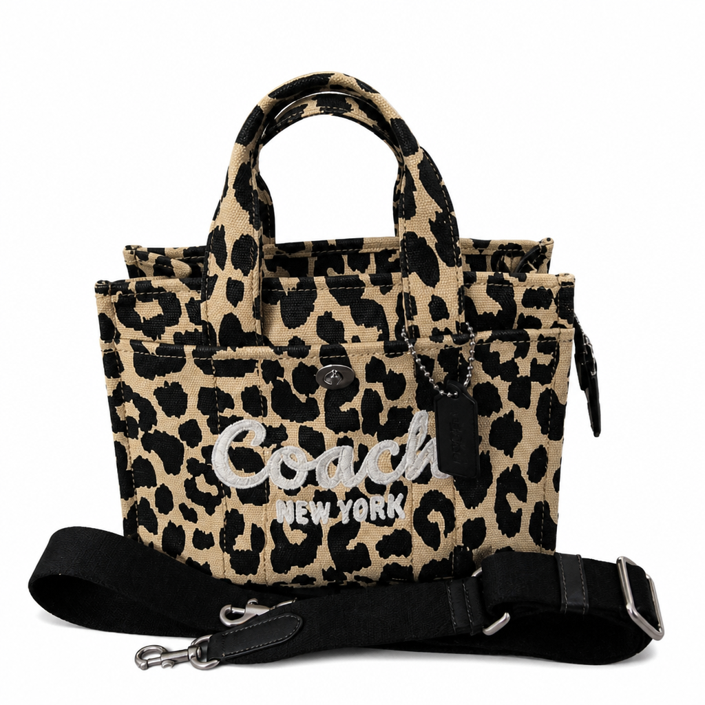 A Coach New York leopard print tote bag with black handles, a black shoulder strap, and silver embroidered logo lettering on a white background. Pre-Owned Coach Cargo Tote  Leopard Print Canvas Bag