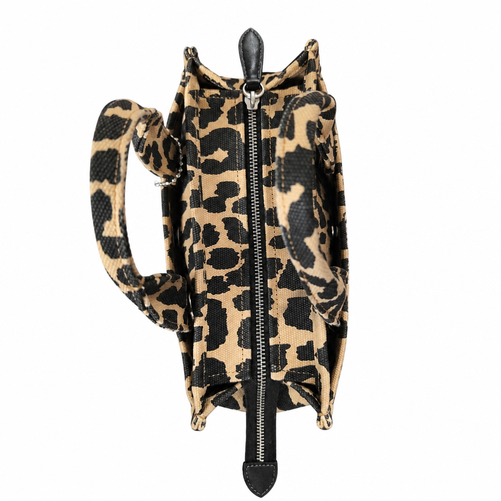 A small leopard-print backpack with a black front zipper, black trim, and a matching shoulder strap, shown on a plain white background. Pre-Owned Coach Cargo Tote  Leopard Print Canvas Bag