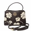A dark brown leather handbag with a gold-tone Tory Burch monogram logo on the front, decorated with cream-colored floral embroidery. The bag features a top handle, a detachable shoulder strap, and is photographed against a clean white background. Pre-Owned Tory Burch  Floral Applique Top Handle Bag