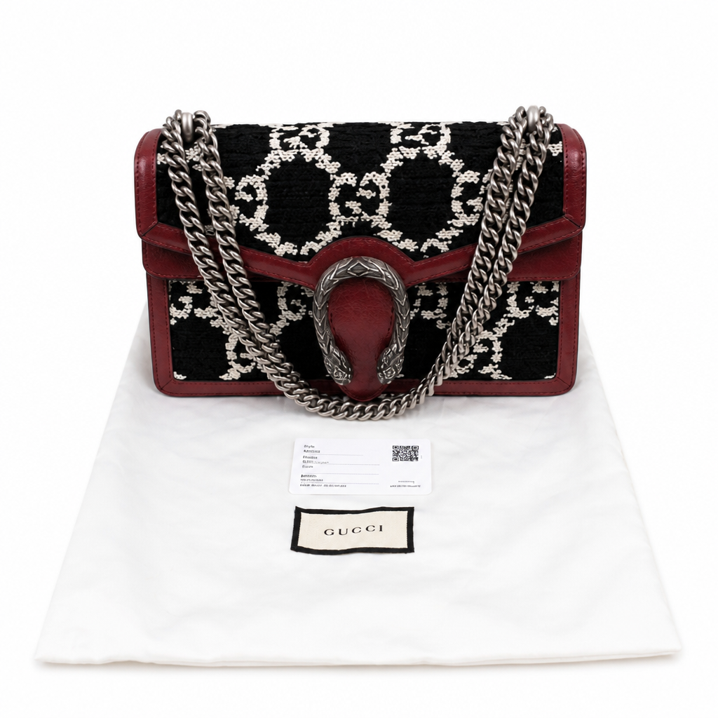 A Gucci Sienne baguette handbag in black and burgundy GG monogram canvas with a silver chain strap and horsebit clasp, displayed on a white dust bag with a Gucci label. Pre-Owned Gucci Dionysus GG Tweed Medium Shoulder Bag – Red/Black