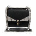 A black leather shoulder bag with a silver-tone chain strap and a distinctive metallic silver and gold 'eyes' design on the front flap, with 'Fendi Roma' printed below the clasp. Pre-Owned Fendi Kan I Monster Eyes Black Leather Chain Shoulder Bag