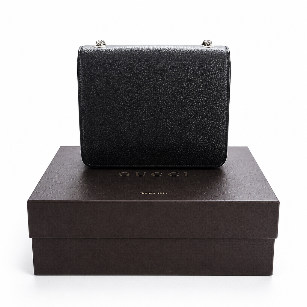 A black textured leather Gucci handbag  hardware, displayed on top of its dark brown branded box against a white background. Pre-Owned Gucci Interlocking Black shoulder bag 