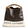 A Louis Vuitton monogram canvas shoulder bag with tan leather trim and handle, displayed above a cream-colored Louis Vuitton dust bag on a white background. Pre-Owned Louis Vuitton Artsy MM Monogram Canvas Shoulder Bag 