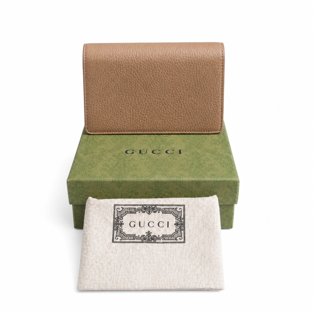 A Gucci leather wallet in tan and green, displayed with its green Gucci box and a white branded dust bag on a white background. Pre-Owned Gucci Dionysus Super Mini Crystal Tiger Head Chain Bag – Beige Leather