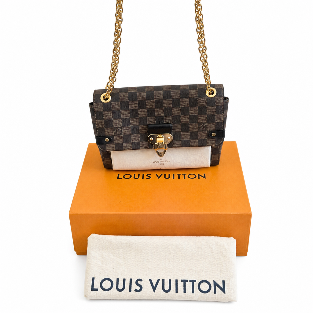 Louis Vuitton Damier Ebene canvas shoulder bag with gold-tone chain strap, displayed on top of an orange Louis Vuitton box with a white dust bag in front. Pre-Owned Louis Vuitton Vavin PM Damier Ebene / Crème – N40113