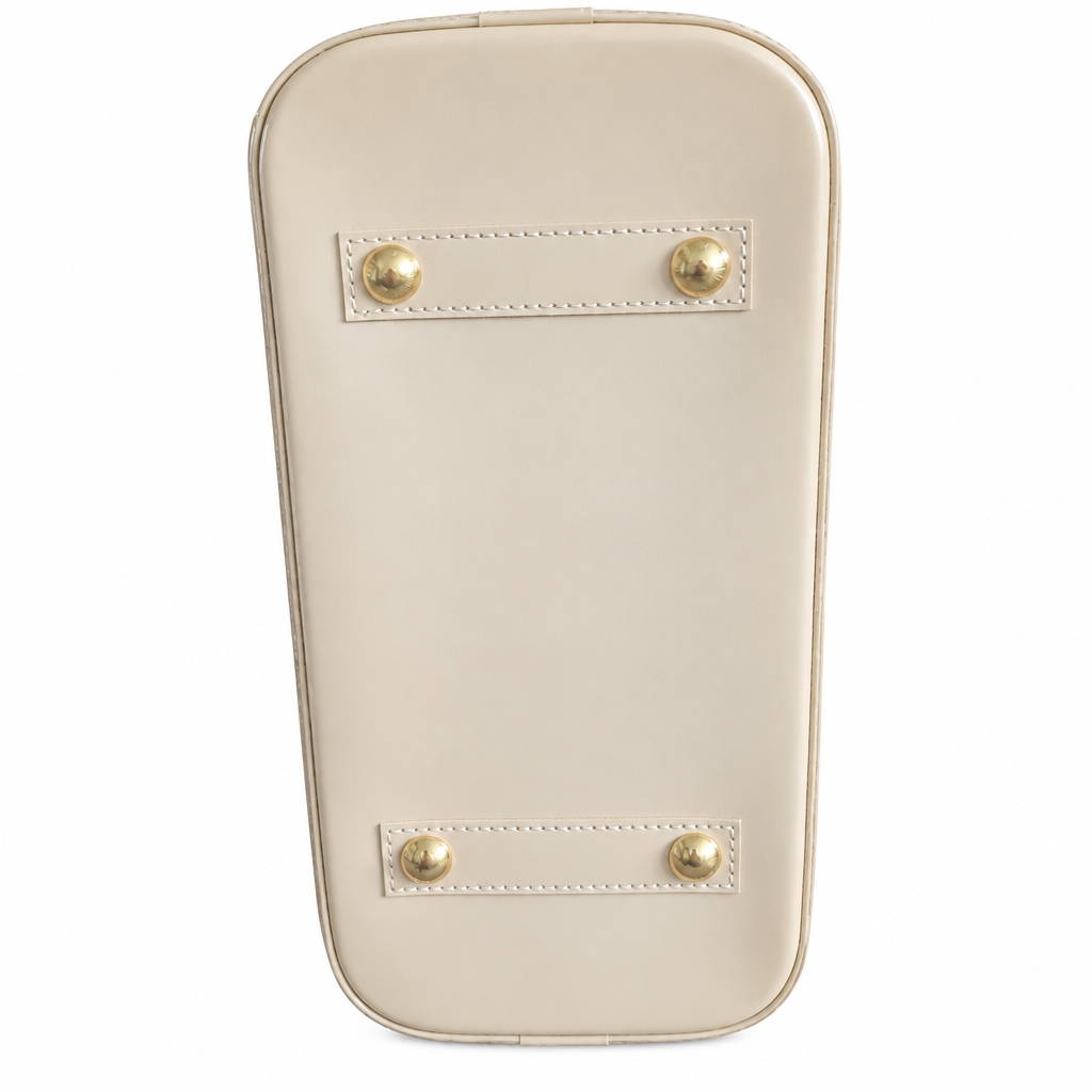 The bottom view of a cream-colored leather clutch or handbag, featuring two horizontal stitched leather bands with gold-tone round studs on a solid white background. Pre-Owned Louis Vuitton Alma PM Monogram Vernis – Beige Poudre