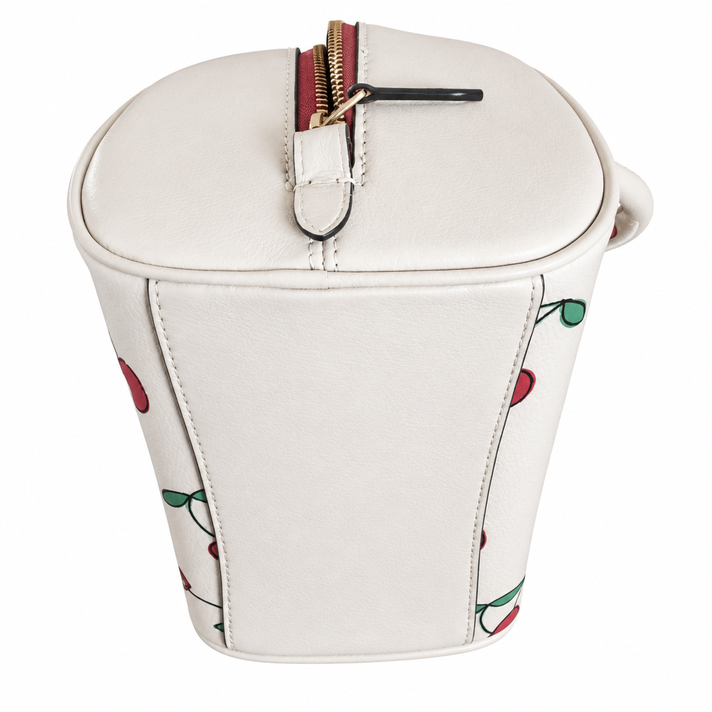An off-white faux leather bucket bag with a cherry pattern and a gold zipper on a white background. Pre-Owned Coach Sydney Satchel With Heart Cherry Print – CF421