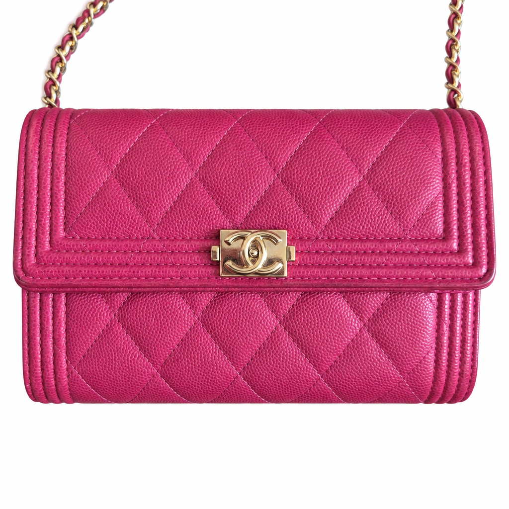 A bright pink quilted leather shoulder bag with a gold-tone turn-lock clasp and a gold-and-pink chain strap, shown on a plain white background. Pre-Owned Chanel Boy Wallet on Chain – Fuchsia Pink Caviar Leather – Gold Hardware