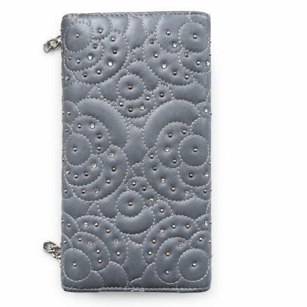 A gray quilted wallet with a scalloped circular pattern and silver rhinestone accents, shown on a plain white background. Pre-Owned Chanel Camellia Studded Wallet on Chain WOC – Blue Lambskin