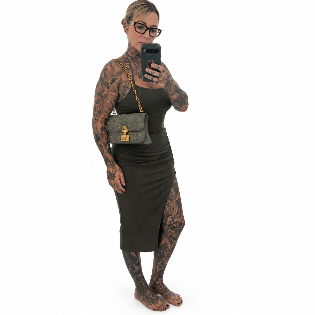 A tattooed woman takes a mirror selfie wearing a black ribbed midi dress, a gray shoulder bag with a gold chain strap, and glasses, against a plain white background. Pre-Owned Christian Dior Small DiorAddict Cannage Studded Flap Bag – Light Blue Lambskin