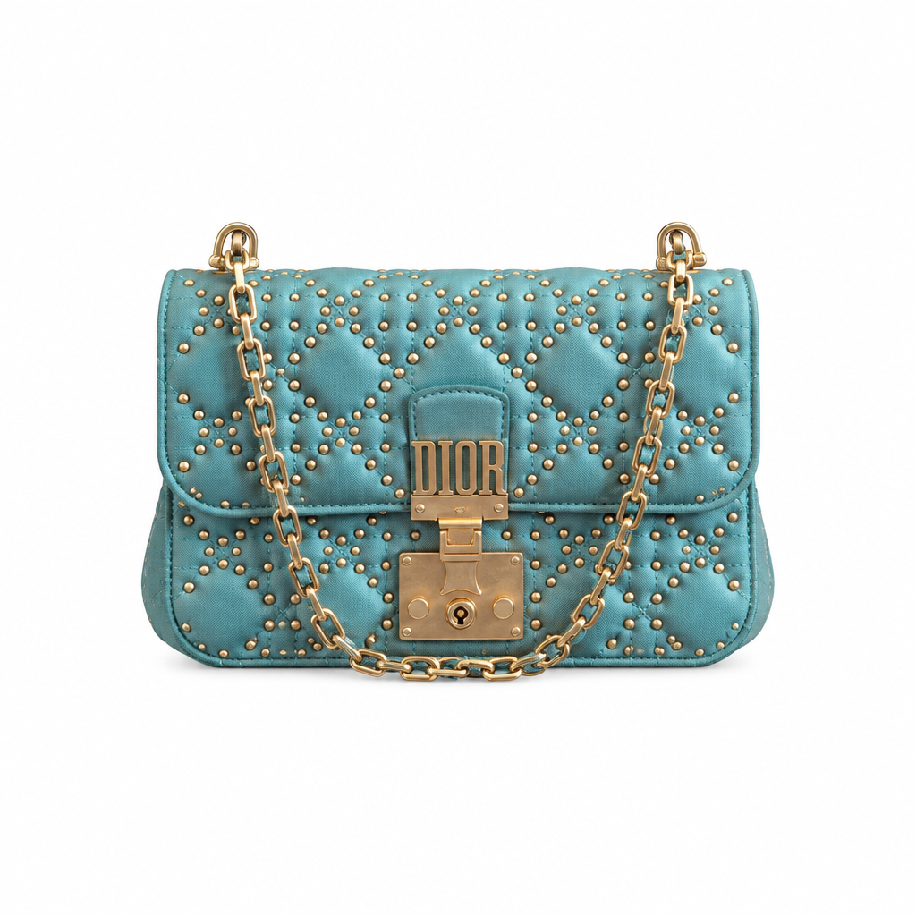 A turquoise blue quilted leather shoulder bag by Dior, adorned with gold studs and a gold-tone chain strap with a central lock closure. Pre-Owned Christian Dior Small DiorAddict Cannage Studded Flap Bag – Light Blue Lambskin