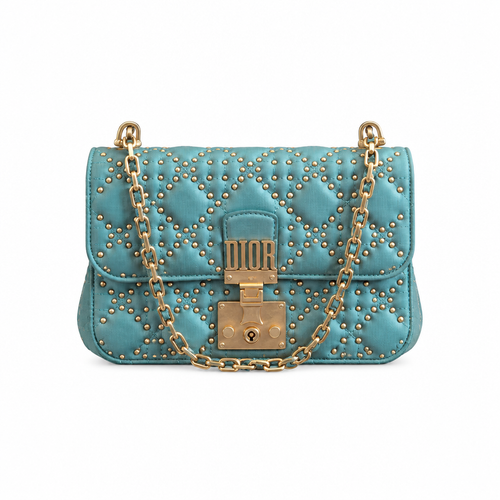 A turquoise blue quilted leather shoulder bag by Dior, adorned with gold studs and a gold-tone chain strap with a central lock closure. Pre-Owned Christian Dior Small DiorAddict Cannage Studded Flap Bag – Light Blue Lambskin