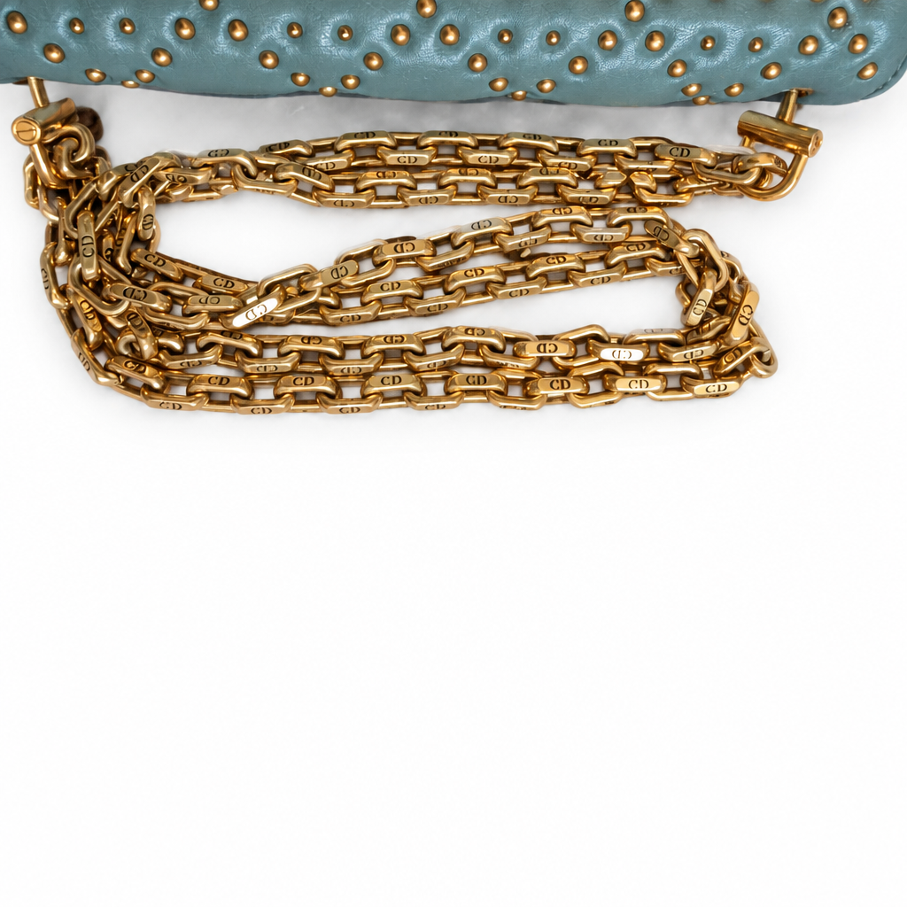 Close-up of a gold-tone chain strap attached to a light blue leather bag with gold studs, shown on a white background. Pre-Owned Christian Dior Small DiorAddict Cannage Studded Flap Bag – Light Blue Lambskin