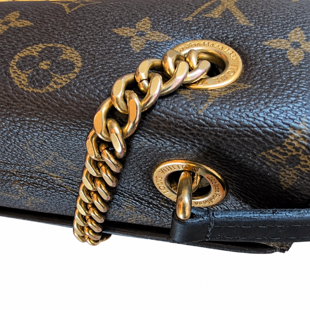 Close-up of a Louis Vuitton handbag in dark brown monogram canvas with a chunky gold-tone chain strap and matching gold hardware. Pre-Owned Louis Vuitton Passy Monogram Shoulder Bag – Burgundy Interior