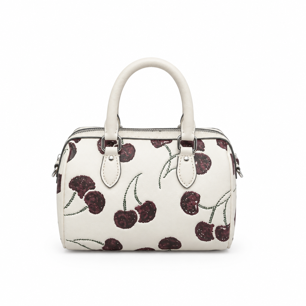 An off-white structured handbag with a cherry pattern, featuring dark cherries  Pre-Owned Coach Rowan Cherry Print Leather Crossbody / Mini Satchel – Chalk Multi
