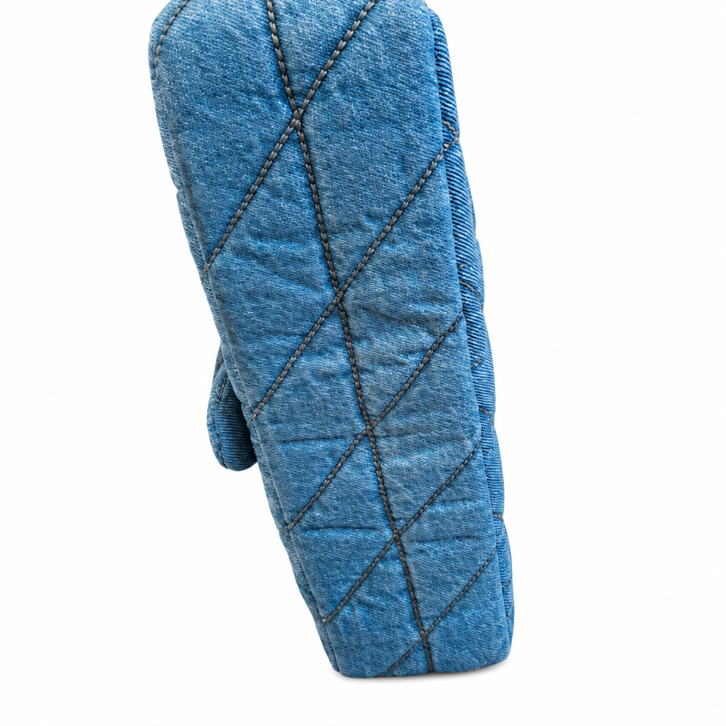 A single quilted blue oven mitt with diagonal diamond stitching, shown against a plain white background. Pre-Owned Coach Quilted Tabby Shoulder Bag 26 – Blue Denim