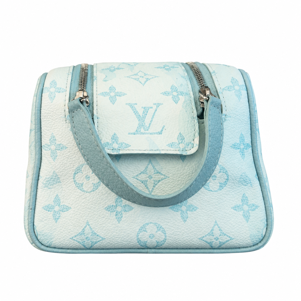 A small Louis Vuitton handbag in light blue and white monogram coated canvas, featuring a top zip closure, a front flap pocket with a silver-tone LV logo, and a matching light blue shoulder strap, shown against a plain white background. Pre-Owned Louis Vuitton x Richard Prince Limited Edition Monogram Bag – Spring/Summer 2008 – Pale Blue
