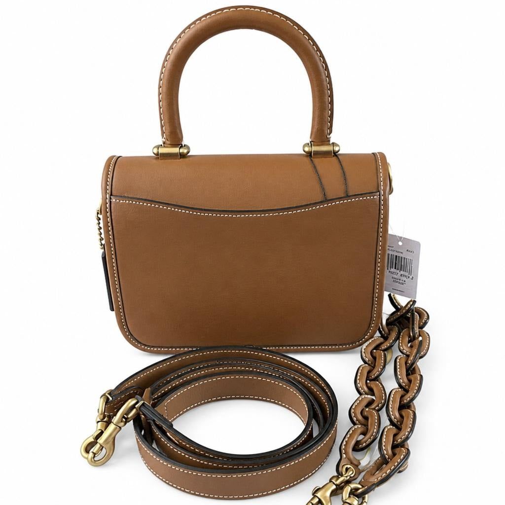 A structured tan leather handbag with a top handle, gold-tone hardware, and an adjustable chain-and-leather shoulder strap, photographed on a clean white background. Pre-Owned Coach Tom Wesselmann Rogue Top Handle Bag