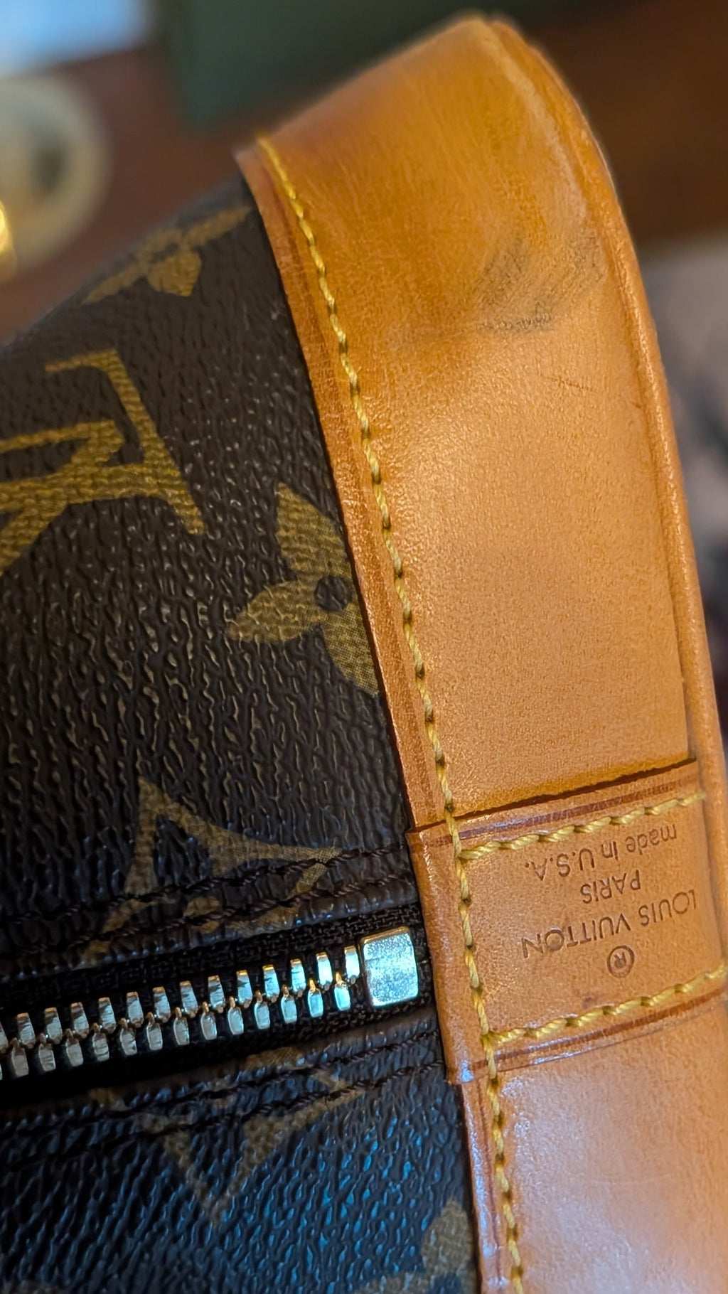 Close-up of a Louis Vuitton handbag with monogram pattern and brown leather trim.