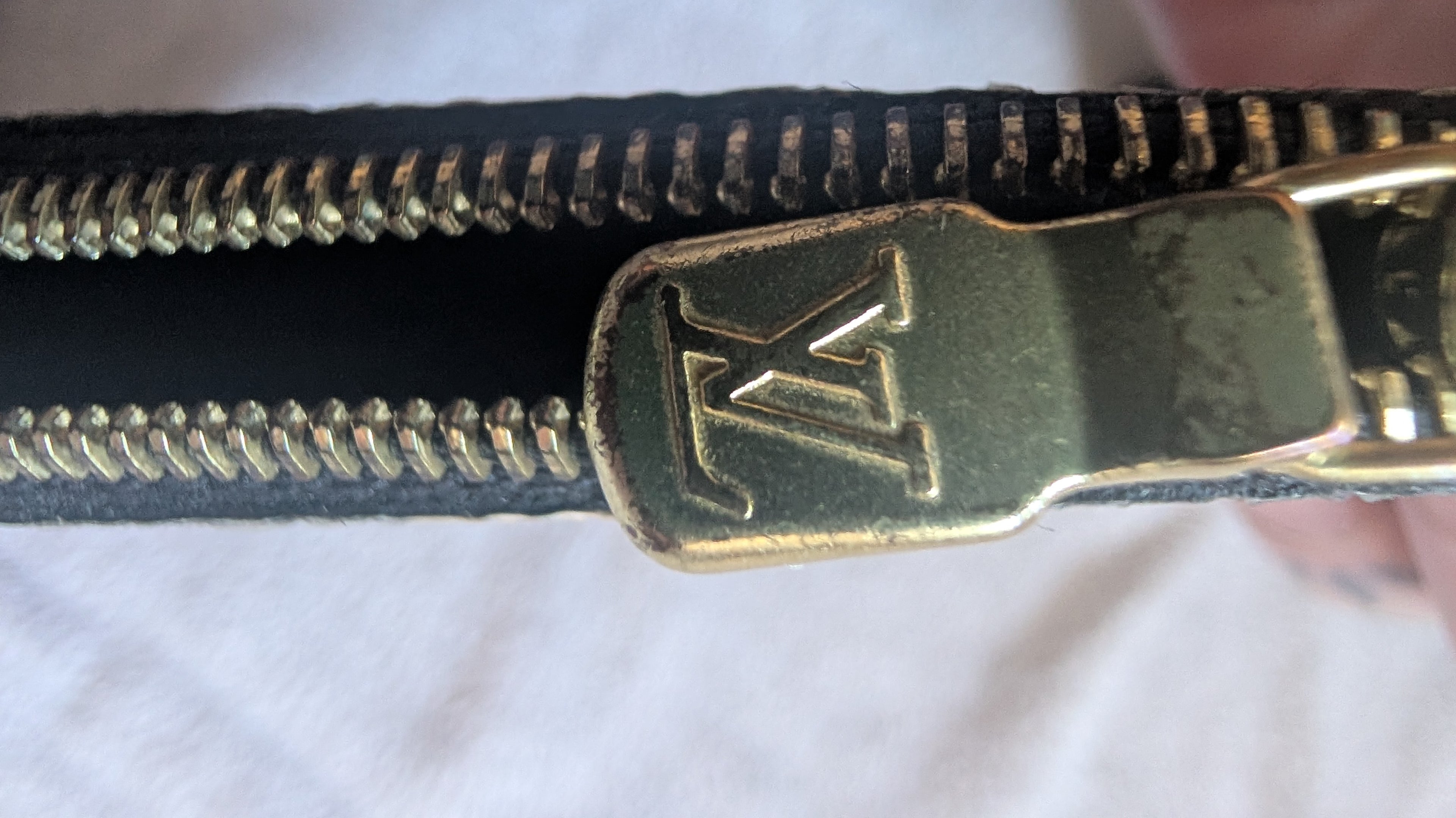Close-up of a gold zipper pull Pre-owned Louis Vuitton Neverfull Pouch Bag