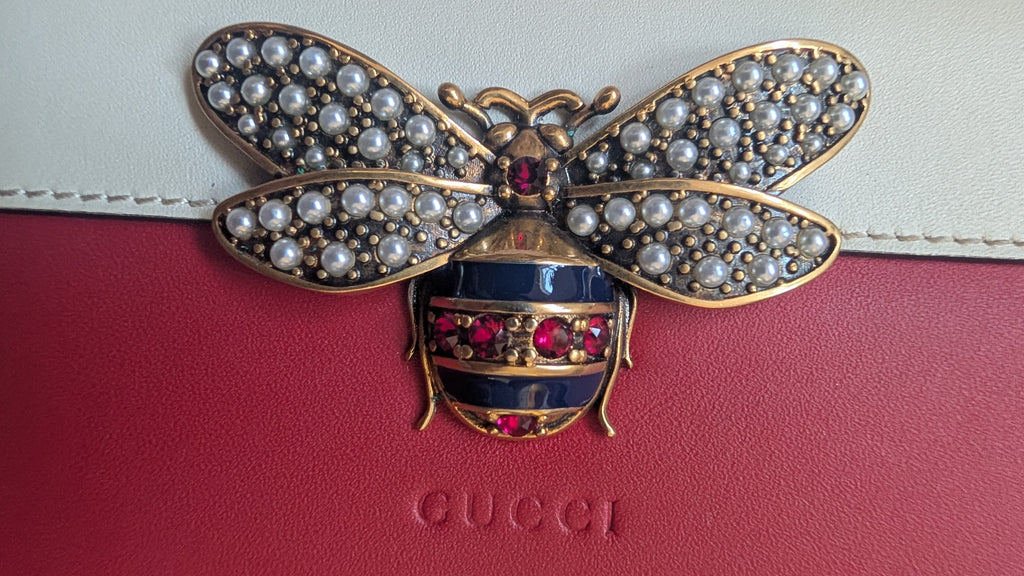 Jeweled bee brooch on a Gucci handbag