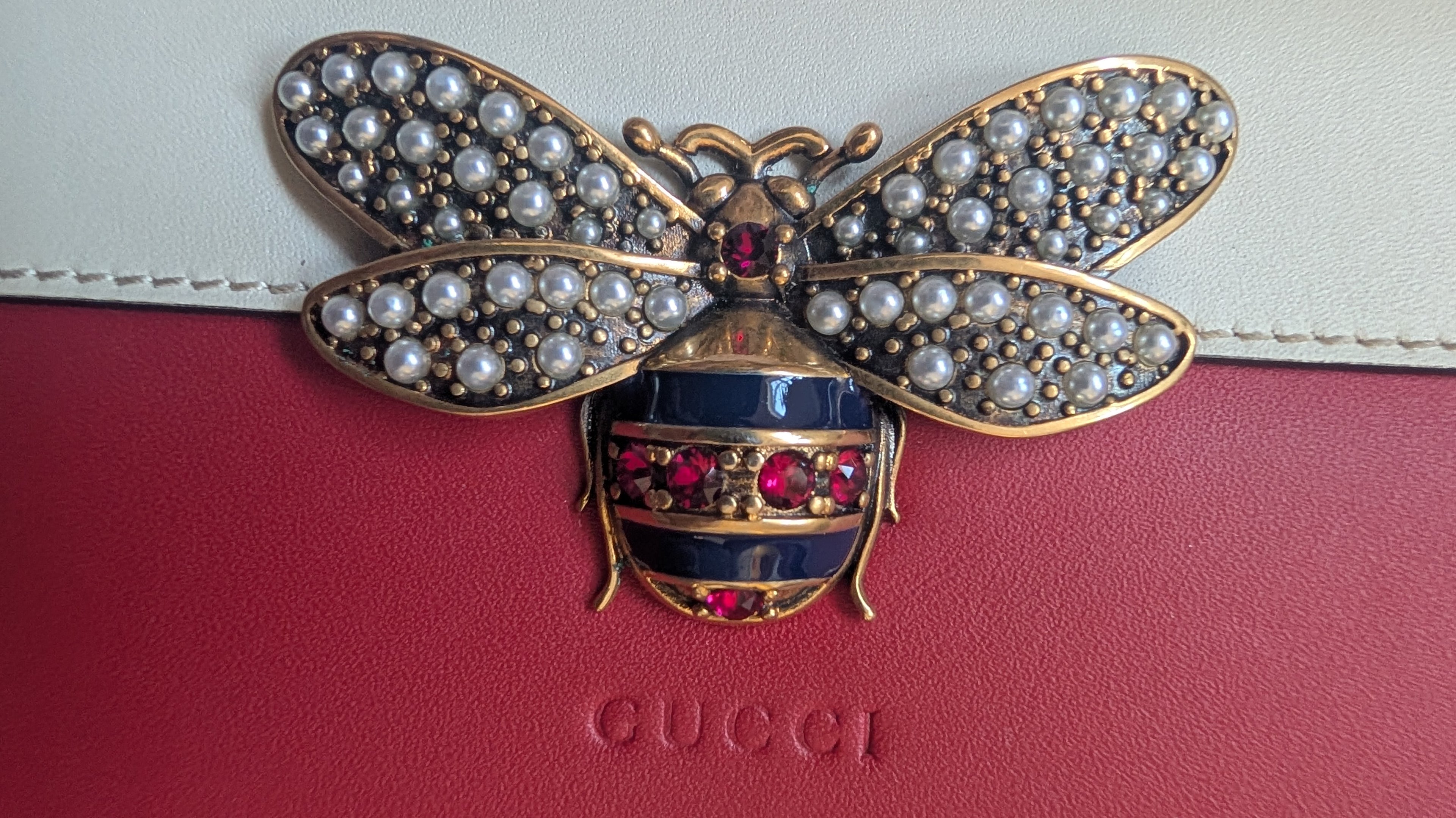 Jeweled bee brooch on a Gucci handbag