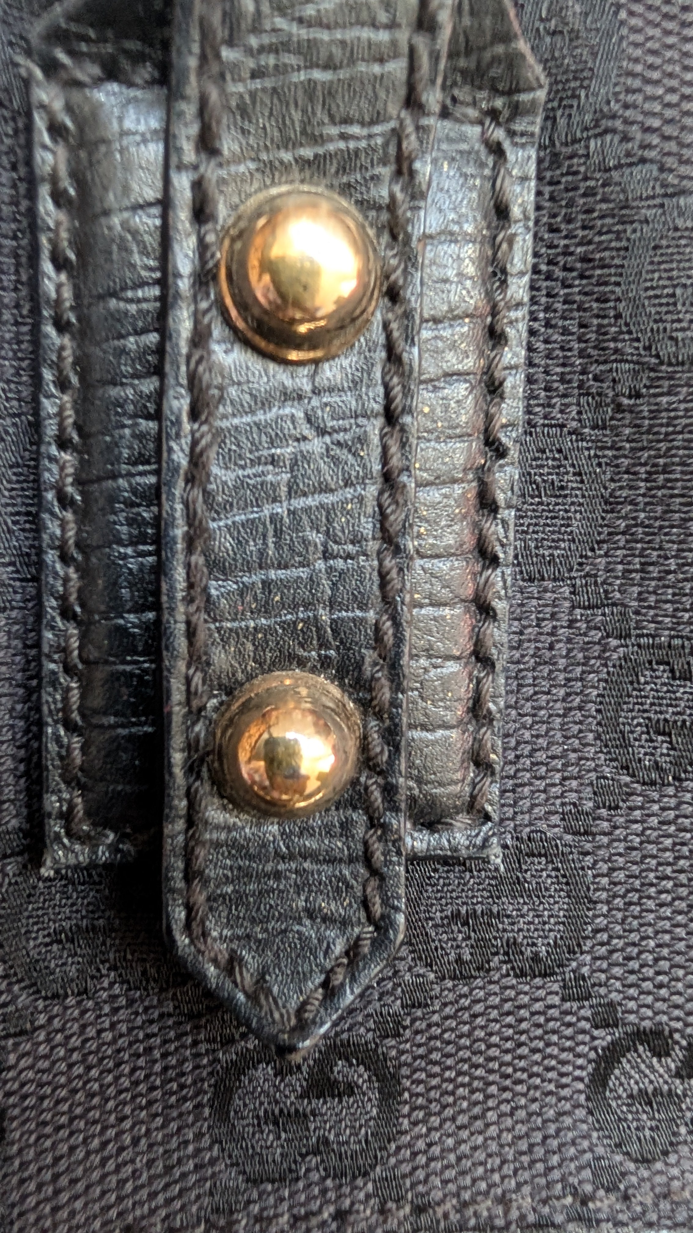 Close-up of a textured fabric with gold buttons Pre-Owned Gucci Horsebit Black Tote