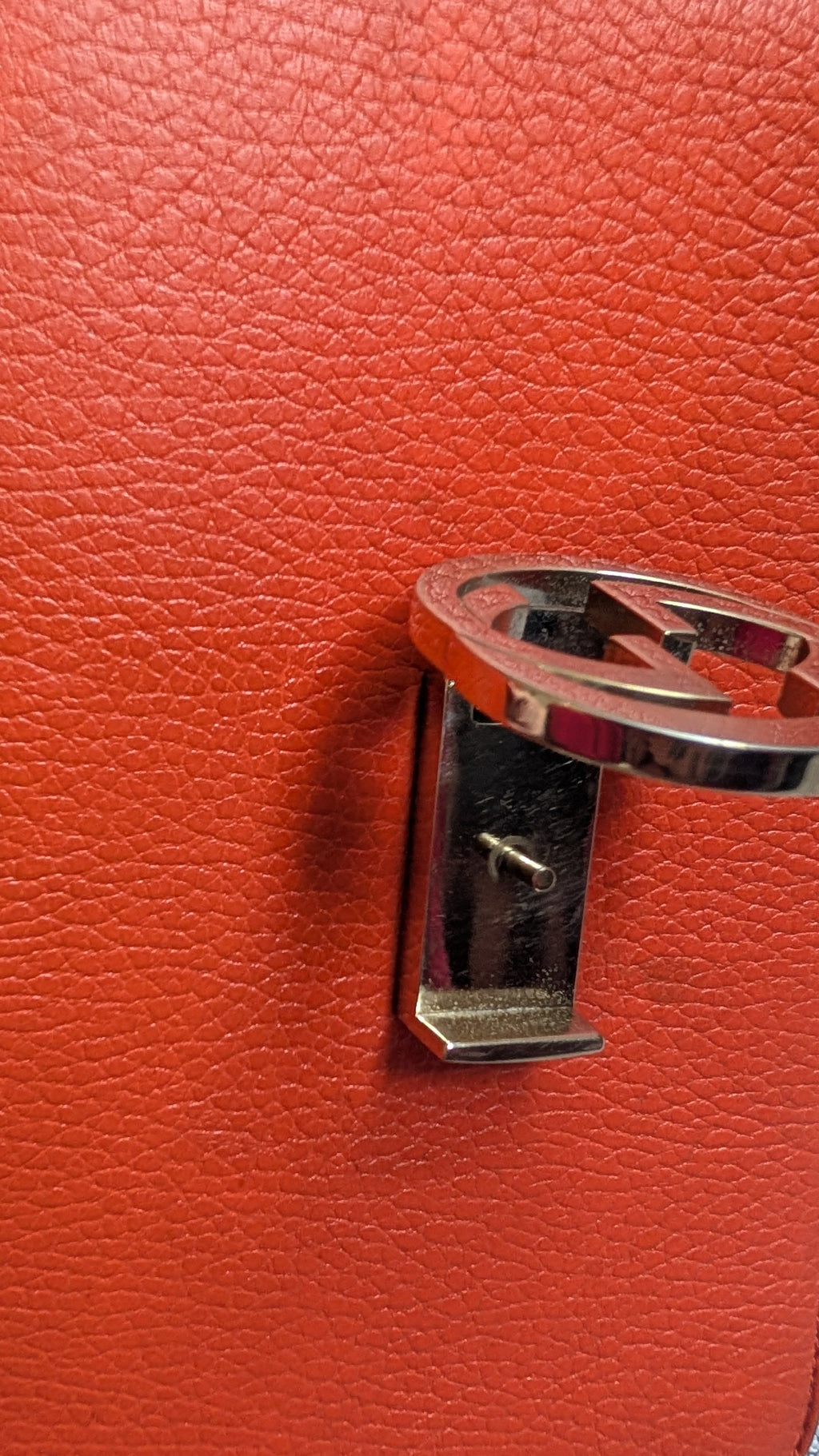 showing close up of marks Orange Gucci GG Interlocking Crossbody Bag 