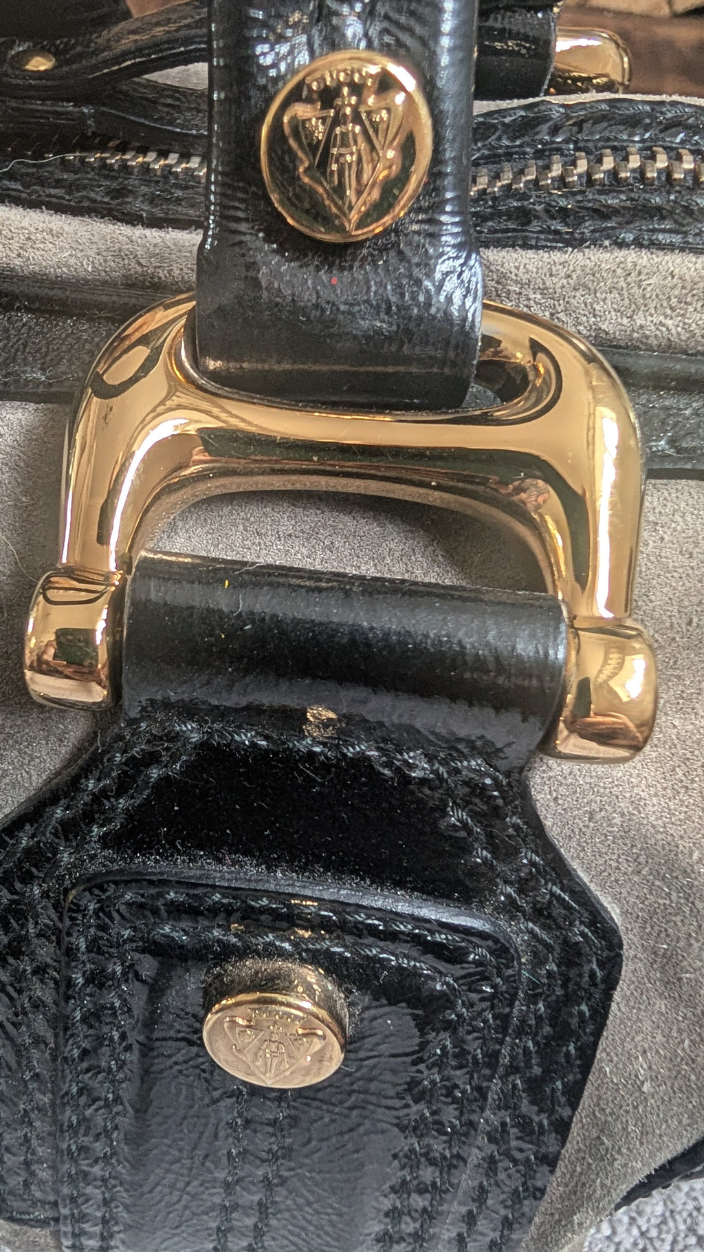 Close-up of a black leather bag with gold hardware and visible brand logo Pre-Owned Gucci Grey Suede Aviatrix Boston Bag.