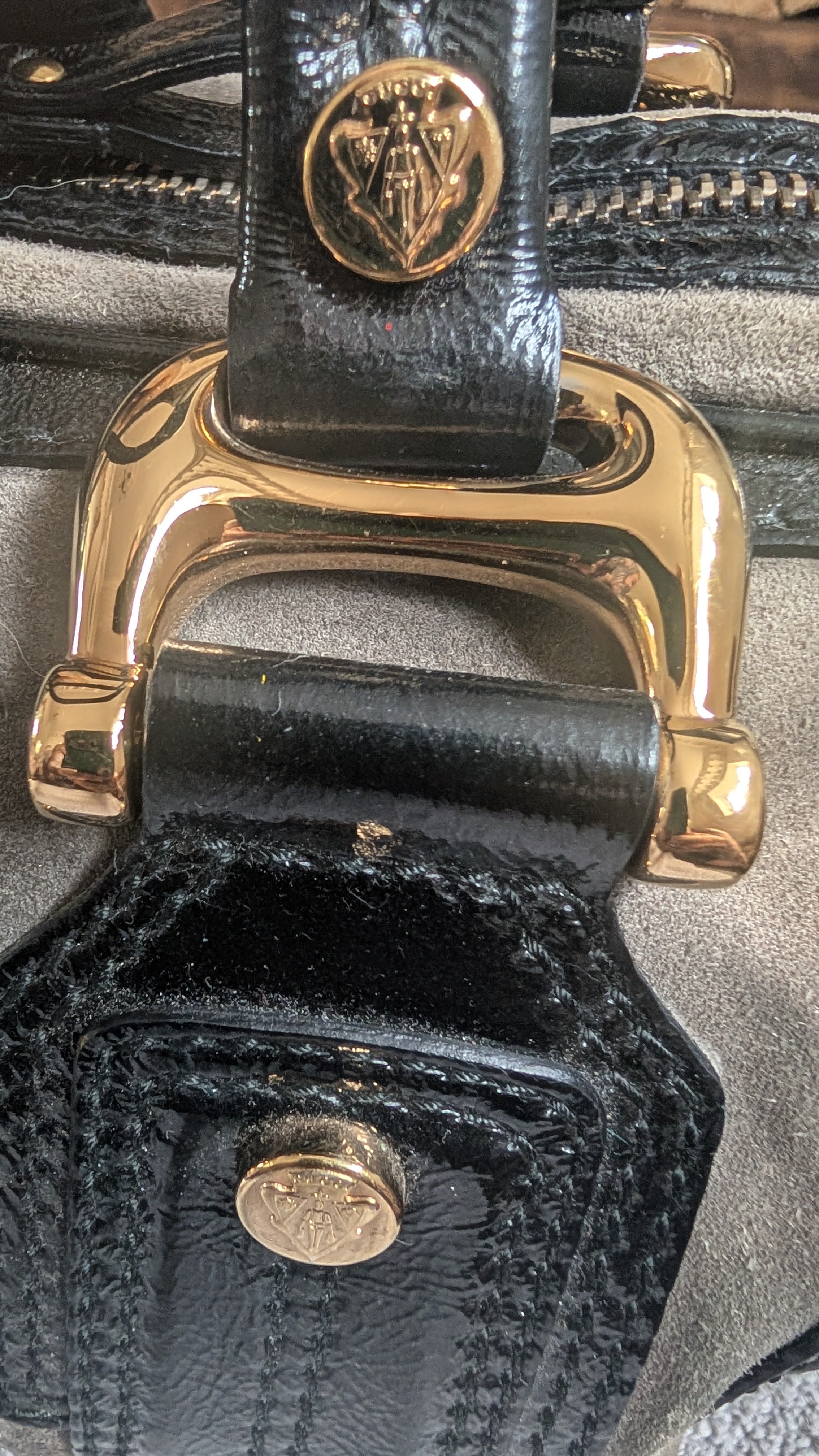 Close-up of a black leather bag with gold hardware and visible brand logo Pre-Owned Gucci Grey Suede Aviatrix Boston Bag.