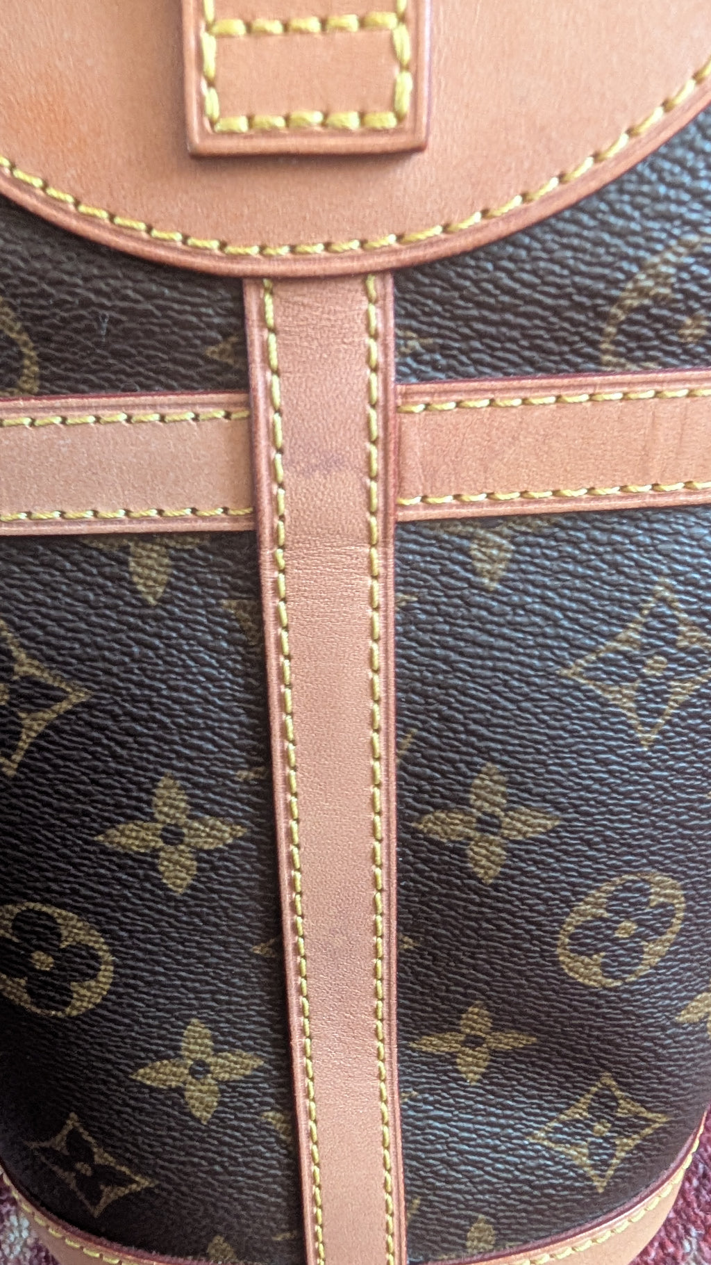 Close-up of a Louis Vuitton monogram canvas bag with tan leather trim and contrast stitching. Pre-Owned Louis Vuitton Duffle Bucket Monogram Canvas - Full Set