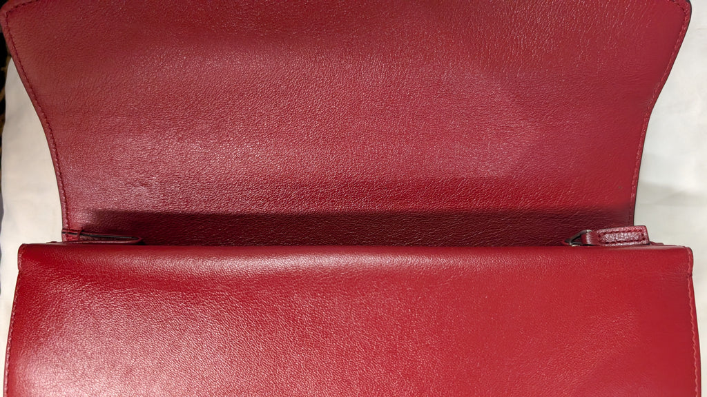A close-up of a red leather clutch or envelope-style handbag shown open, highlighting the interior flap and exterior front panel. Pre-Owned Gucci Dionysus GG Tweed Medium Shoulder Bag – Red/Black
