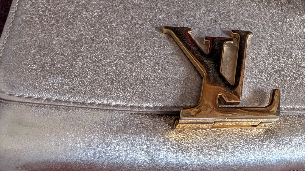 close up of clasp Pre-Owned Louis Vuitton Louise GM Clutch – Metallic Champagne Leather