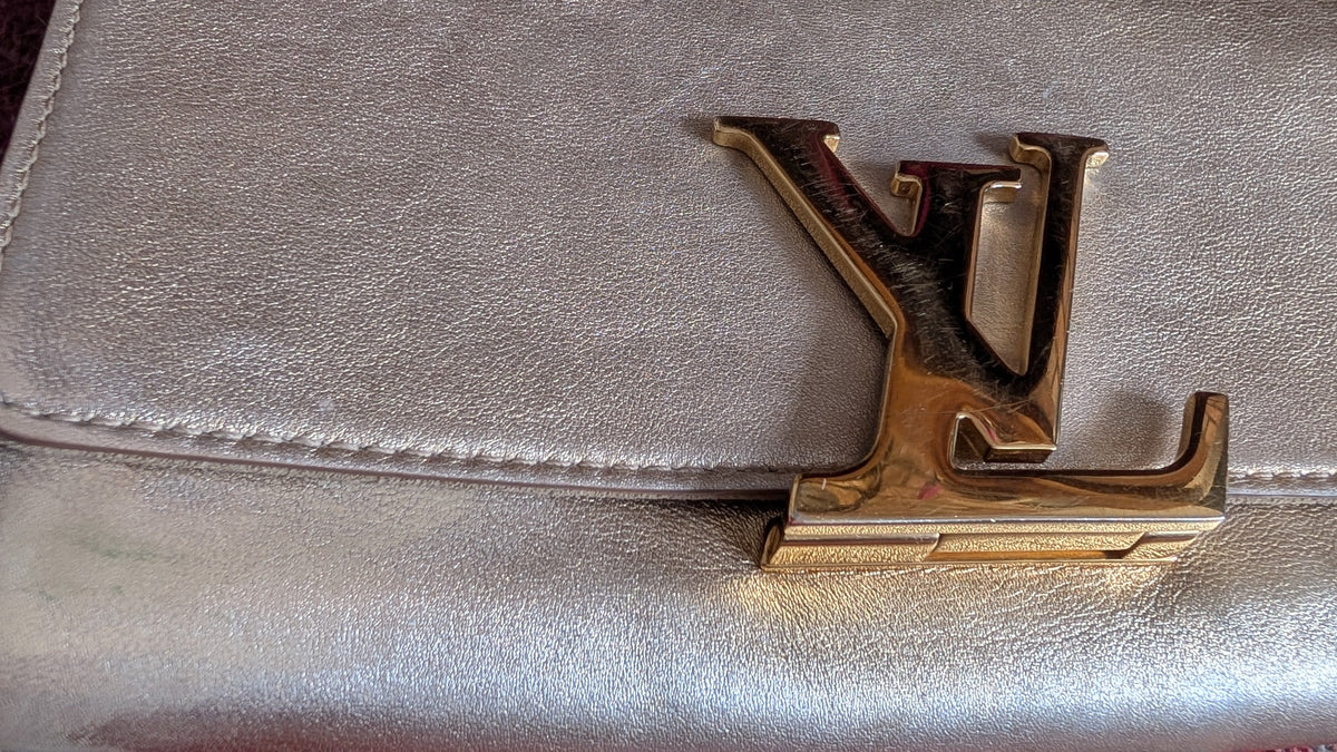 close up of clasp Pre-Owned Louis Vuitton Louise GM Clutch – Metallic Champagne Leather
