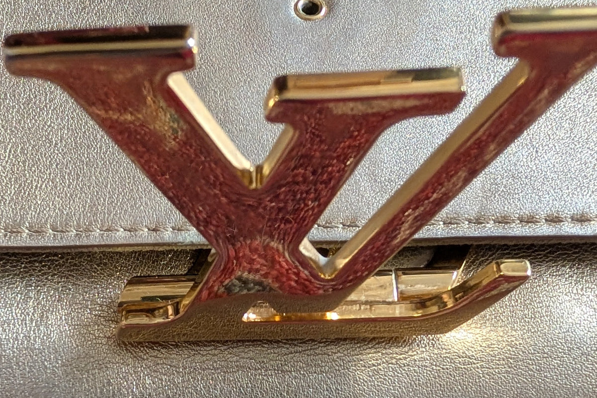 close up of hardware Pre-Owned Louis Vuitton Louise GM Clutch – Metallic Champagne Leather