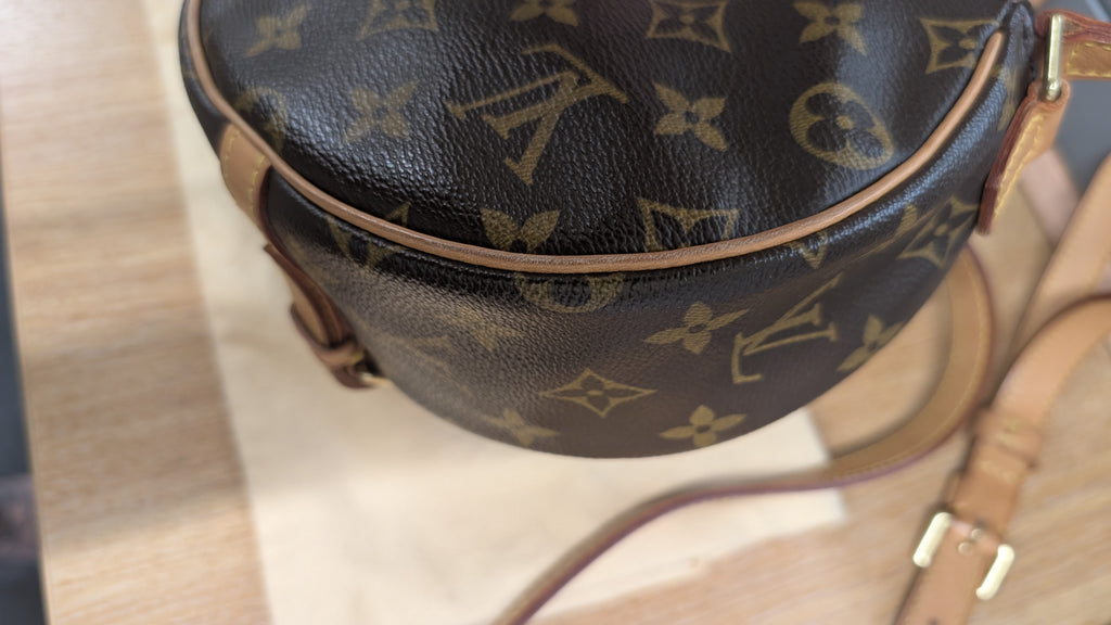 A close-up of a Louis Vuitton monogrammed leather bag, showing the dark brown coated canvas with tan monogram motifs and light brown leather trim and strap. Pre-Owned Louis Vuitton Monogram Tambourin Shoulder / Crossbody Bag