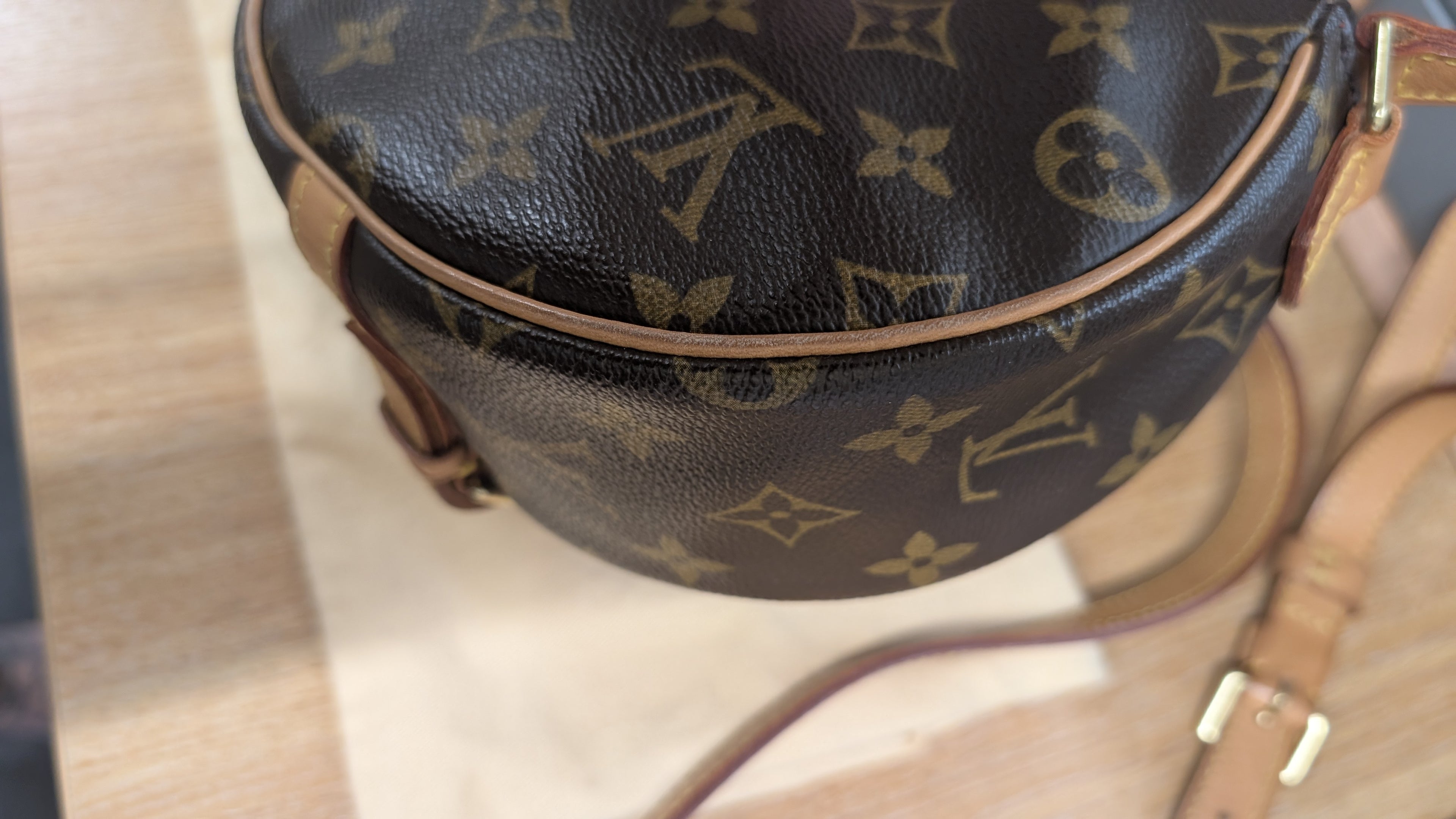 A close-up of a Louis Vuitton monogrammed leather bag, showing the dark brown coated canvas with tan monogram motifs and light brown leather trim and strap. Pre-Owned Louis Vuitton Monogram Tambourin Shoulder / Crossbody Bag