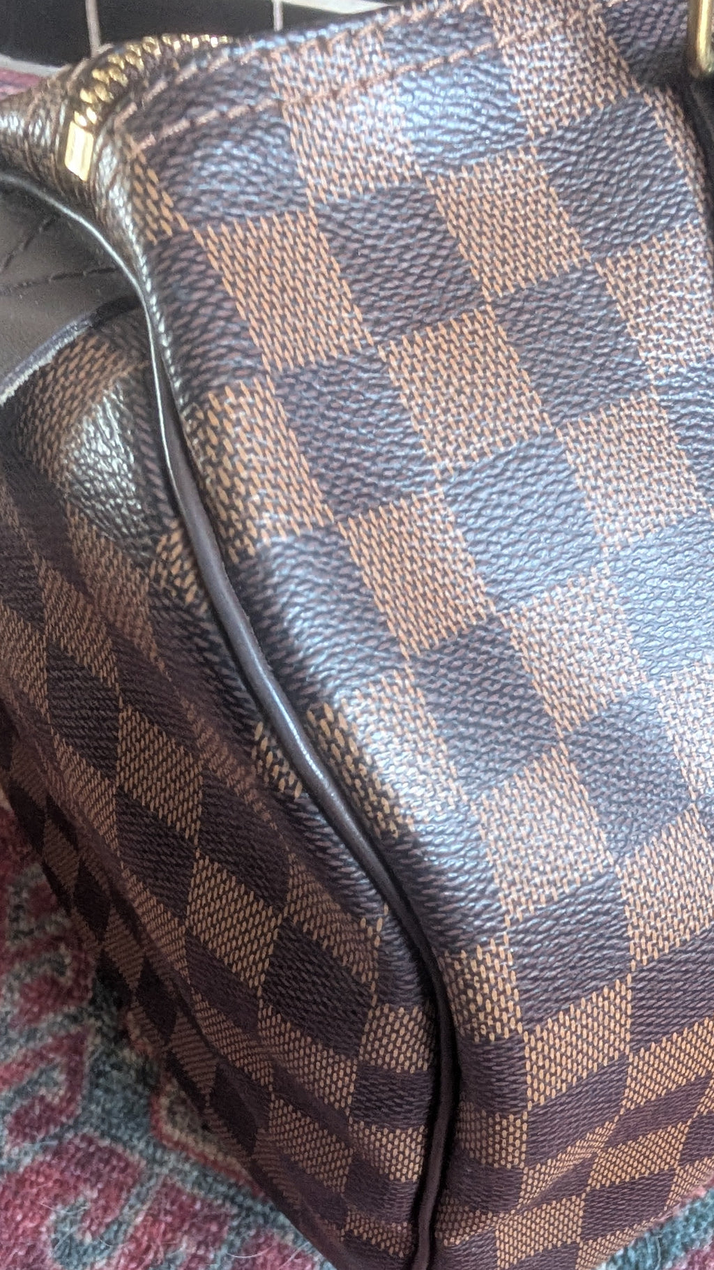 a close up of Pre-Owned Louis Vuitton Speedy 30 Damier Ebene