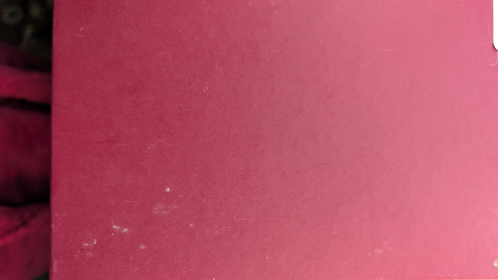 A close-up of a dusty RED textured surface, likely a book cover or notebook page, with some minor scuffs visible on the left edge. Pre-Owned Gucci GG Supreme Ophidia Panda Mini Chain Shoulder Bag