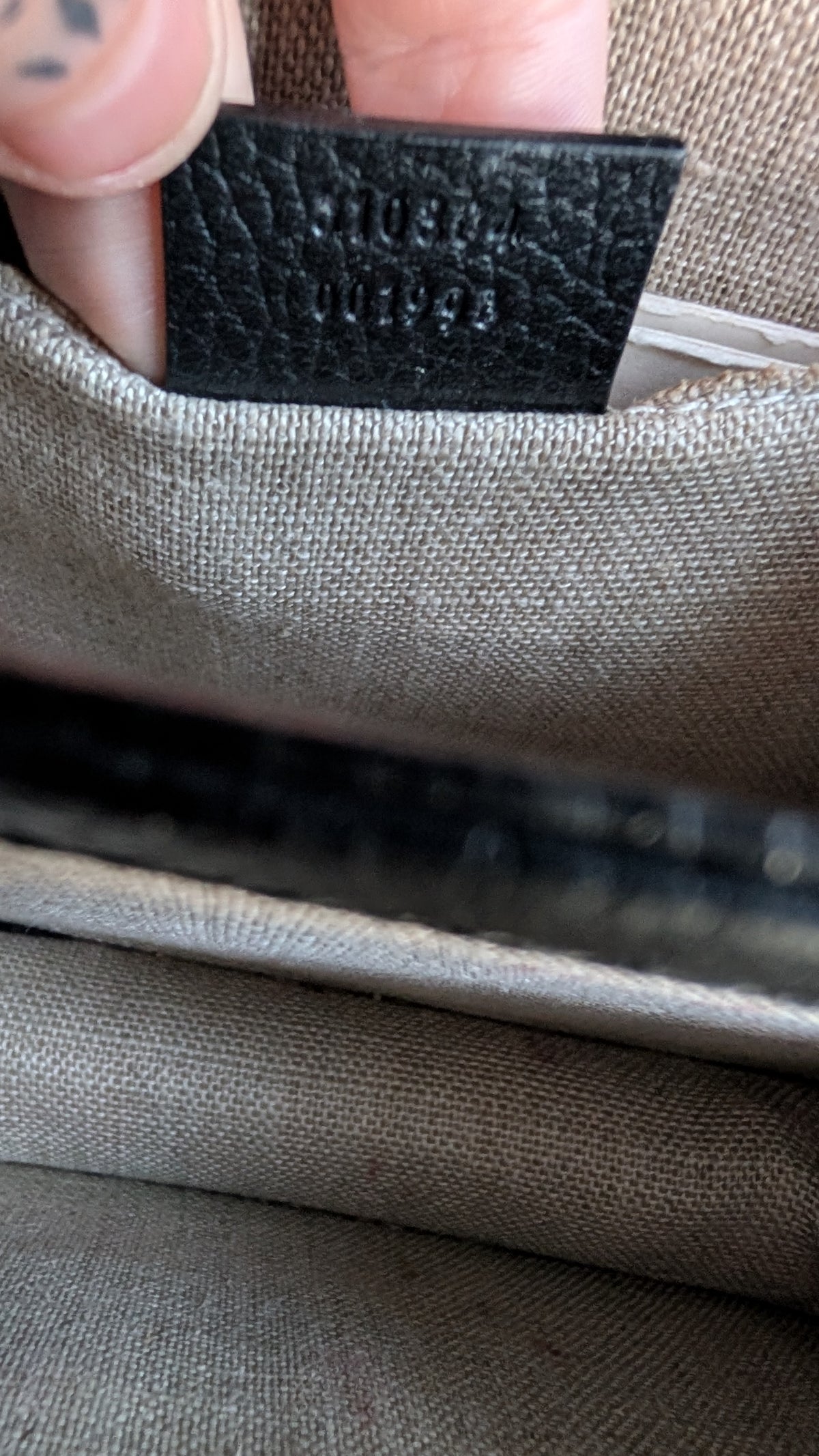 Close-up of a beige woven fabric bag with a black leather interior tag showing the embossed brand name Pre-Owned Gucci Interlocking Black shoulder bag 