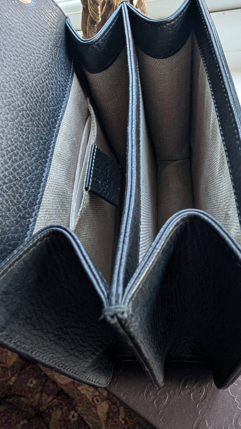 Close-up of the interior of a black textured leatheR BAG showing multiple vertical card slots and a light beige fabric lining. Pre-Owned Gucci Interlocking Black shoulder bag 