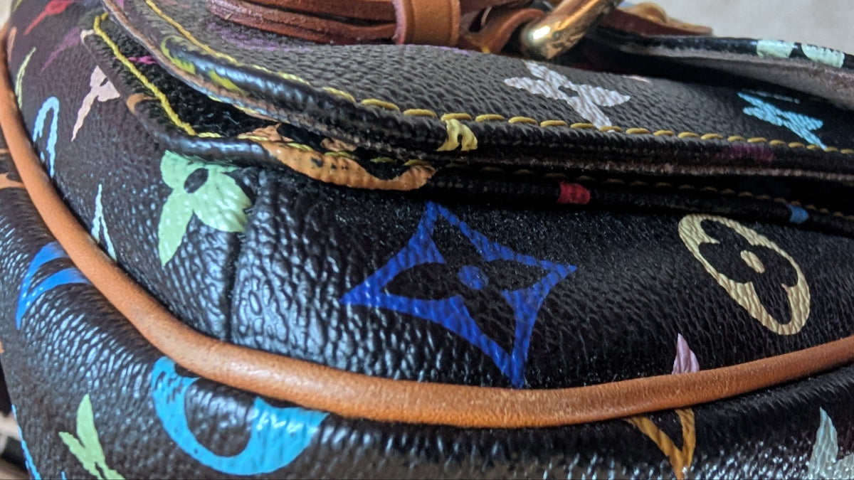 Close-up of a Louis Vuitton monogram bag in black coated canvas with multicolor printed motifs and tan leather trim, showing a zipper and gold-tone hardware. Pre-Owned Louis Vuitton Takashi Murakami Lodge PM Shoulder Bag
