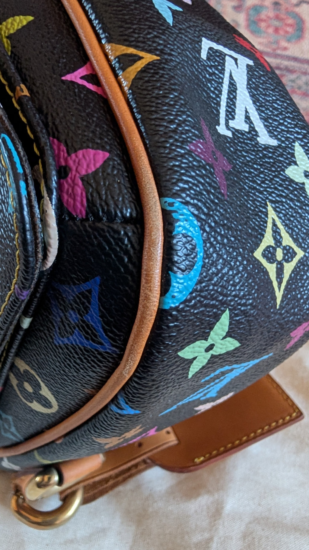 Close-up of a Louis Vuitton monogram backpack in black coated canvas with vibrant multicolor floral motifs and tan leather trim. Pre-Owned Louis Vuitton Takashi Murakami Lodge PM Shoulder Bag