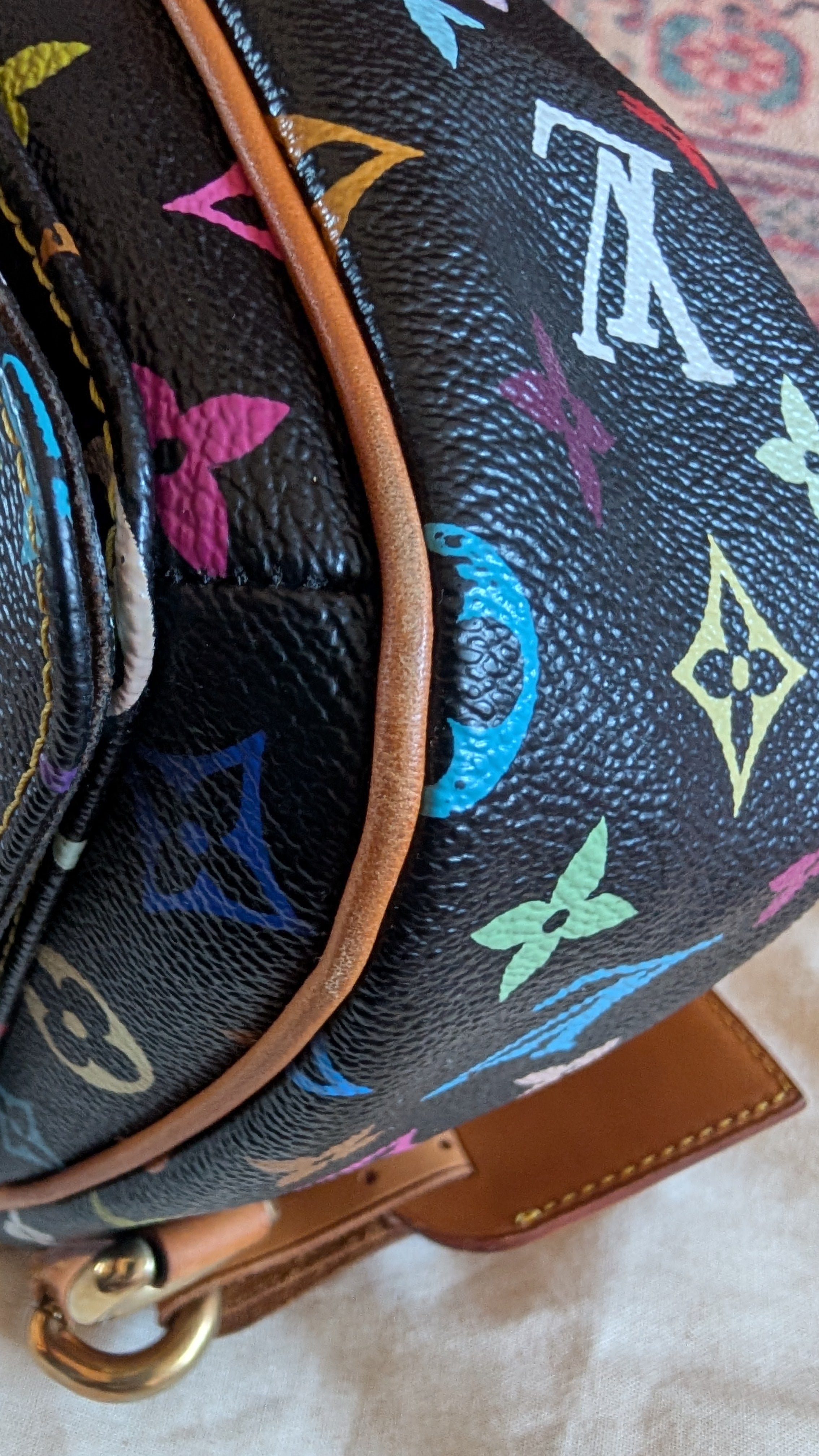 Close-up of a Louis Vuitton monogram backpack in black coated canvas with vibrant multicolor floral motifs and tan leather trim. Pre-Owned Louis Vuitton Takashi Murakami Lodge PM Shoulder Bag