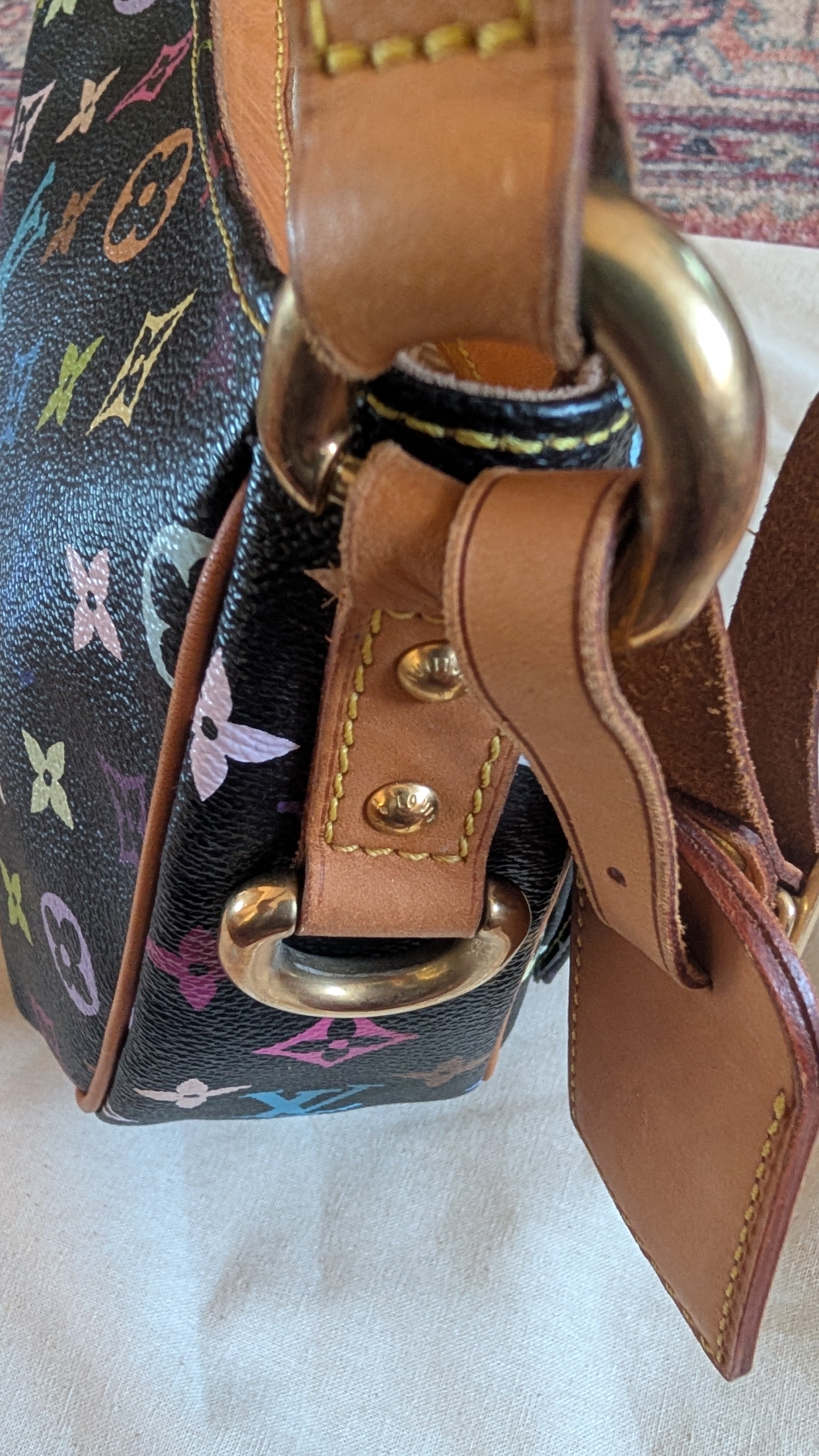 Close-up of a Louis Vuitton shoulder bag featuring the iconic multicolor monogram canvas, tan leather trim, and a large gold-tone metal ring closure. Pre-Owned Louis Vuitton Takashi Murakami Lodge PM Shoulder Bag