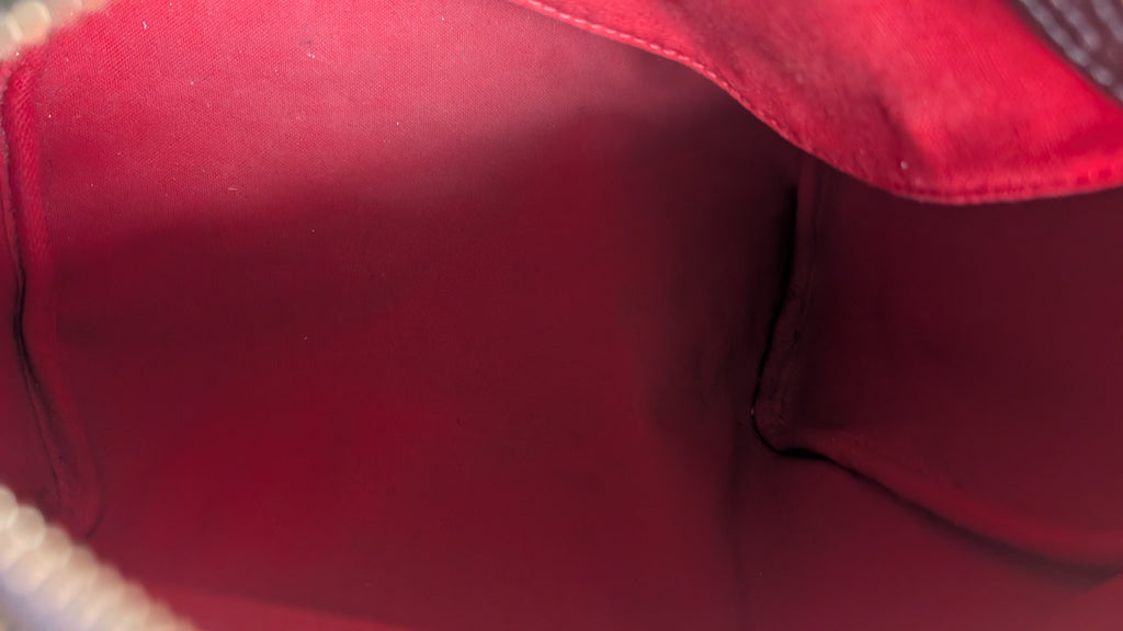 Close-up view of the interior lining of a red bag or pouch, showing the fabric texture and stitched edges. Pre-Owned Louis Vuitton Speedy 25 in classic Damier Ebene coated canvas