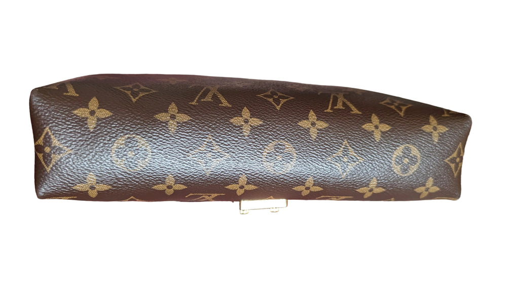 A brown Louis Vuitton monogram clutch bag with gold-tone hardware, held by a tattooed hand over a red and blue patterned rug. Pre-Owned Louis Vuitton Pallas Chain Monogram Canvas Shoulder Bag – Cerise Red – M41201