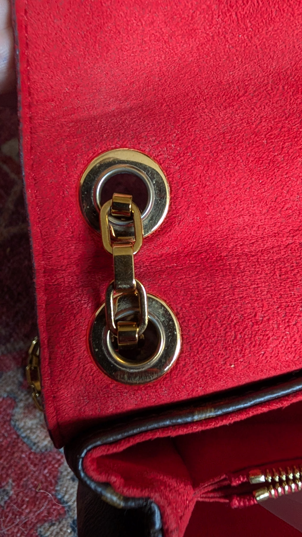Close-up of a red textured handbag featuring a gold-tone metal turn-lock closure and zipper pull. Pre-Owned Louis Vuitton Pallas Chain Monogram Canvas Shoulder Bag – Cerise Red – M41201