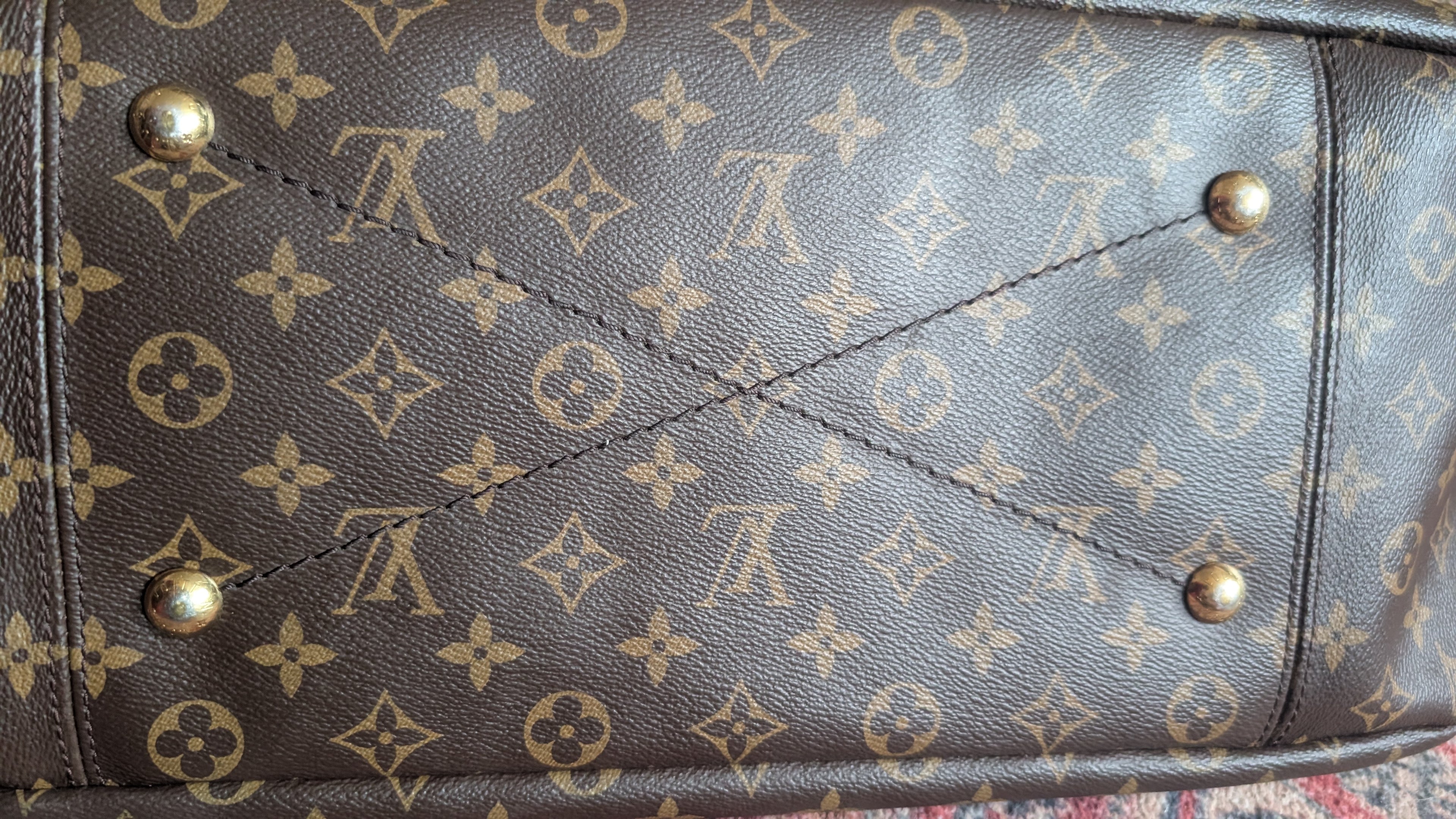 Close-up of a Louis Vuitton monogram canvas bag, showing the classic brown and tan pattern with brass-tone metal studs. Pre-Owned Louis Vuitton Artsy MM Monogram Canvas Shoulder Bag 
