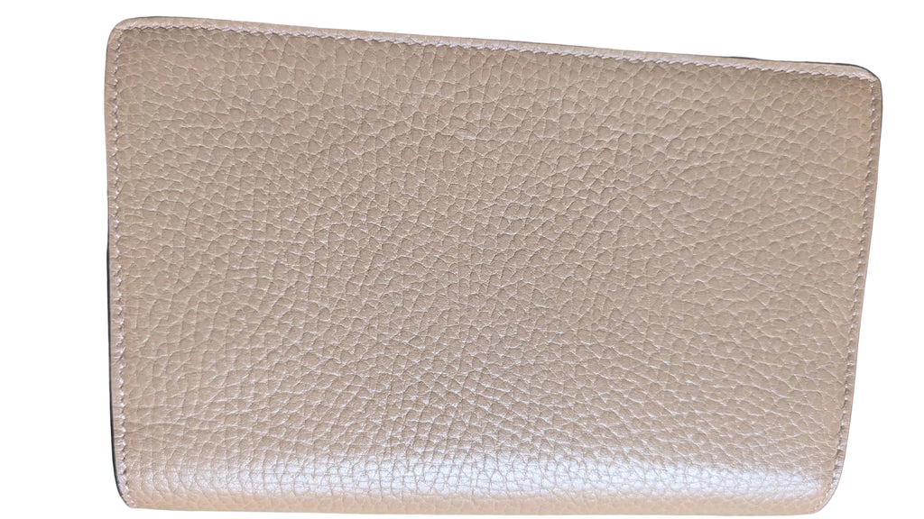 A close-up of a beige pebbled leather wallet or card holder, showing the texture and stitching, resting on a green surface. Pre-Owned Gucci Dionysus Super Mini Crystal Tiger Head Chain Bag – Beige Leather